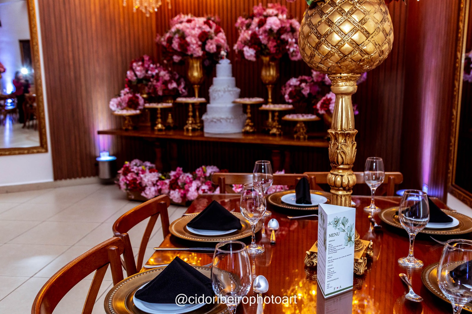 Mesa posta com decoração dourada e flores no Espaço Montello